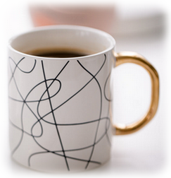 Großaufnahme Kaffeepot in weis mit Kaffee gefüllt auf einem Schreibtisch.