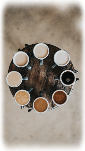 Tisch mit 8 tassen befüllt mit verschieden Kaffeespezialitäten